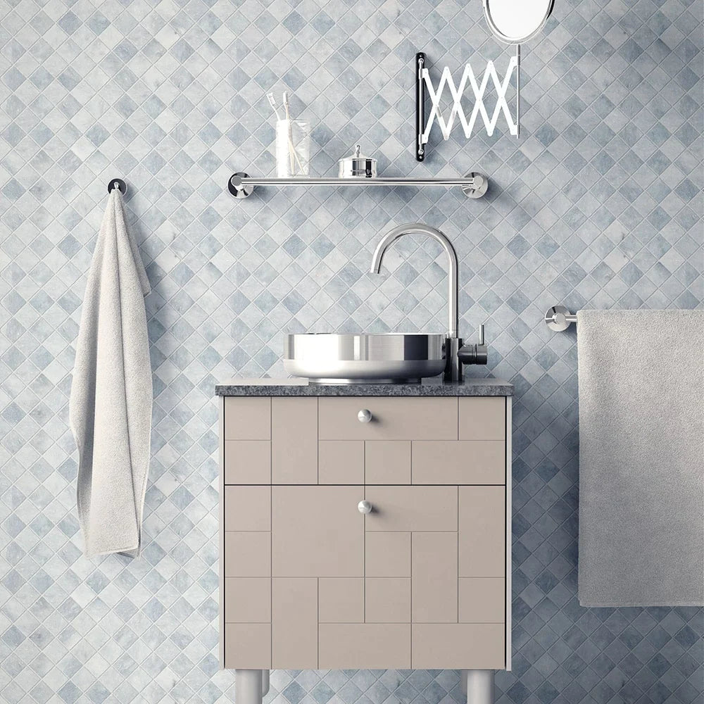 Modern bathroom with light grey mosaic tile wall, sleek vanity with metallic sink, towel rack, mirror, and glass shelf with essentials.