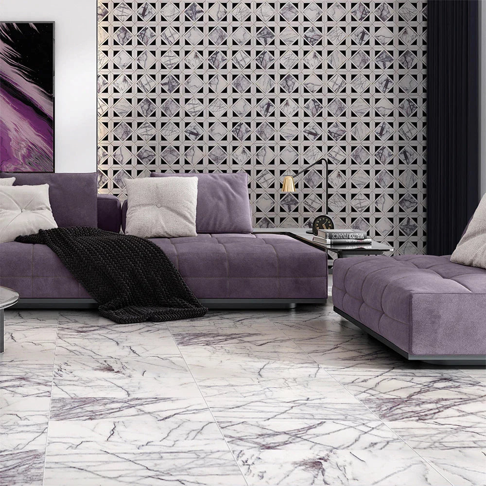 Modern living room with lilac marble tiles, geometric accent wall, purple velvet sofas, white and gray pillows, black blanket, and contemporary art.