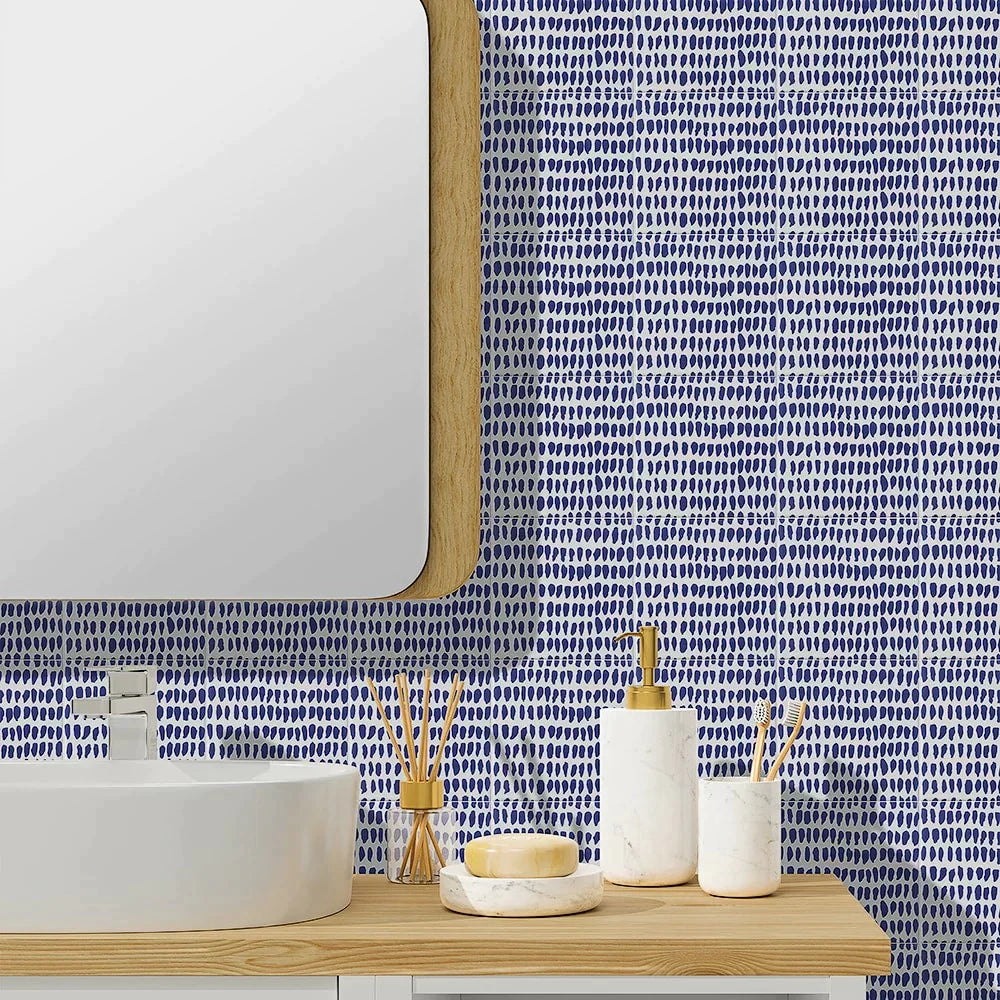 Vibrant blue Sister Parish Ceramic wall with playful dotted pattern, modern white basin, natural wood accents create lively, serene bathroom.
