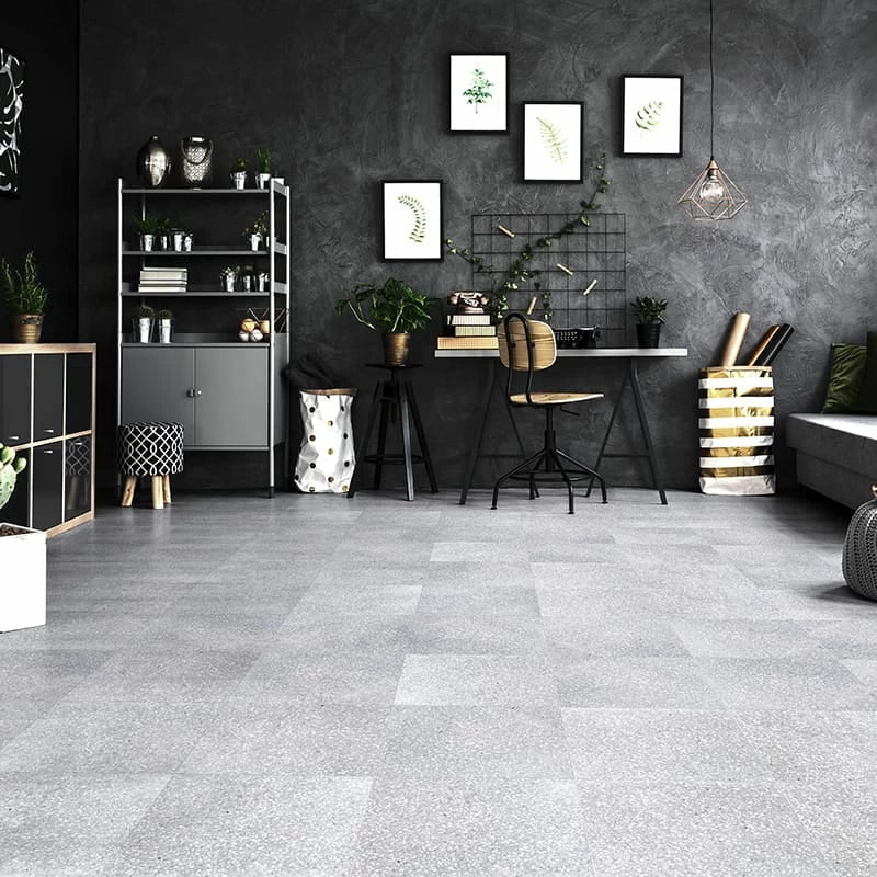 Modern room with gray Venetian-style terrazzo flooring, black accent wall, desk, chair, potted plants, and decorative elements.