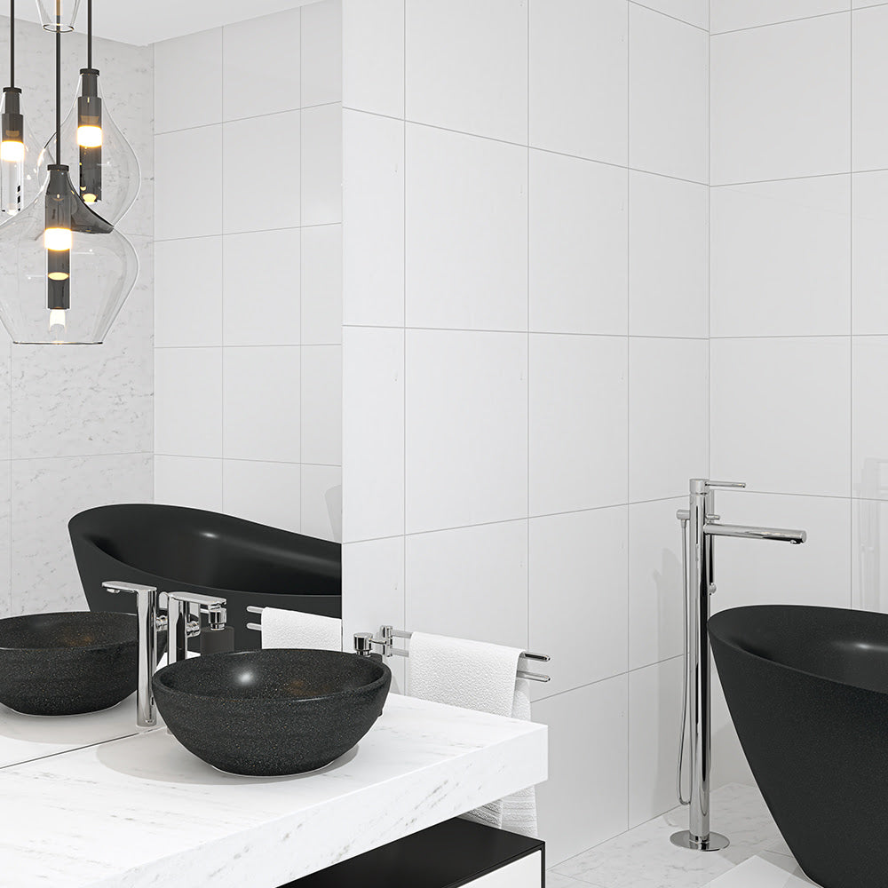 Modern bathroom with white marble tiles, black freestanding bathtub, vessel sinks, chrome fixtures, and contemporary pendant lights.