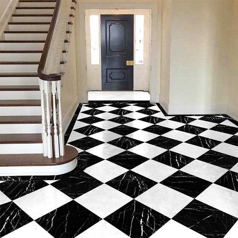 Elegant hallway with black and white checkered marble flooring, white staircase, wooden handrail, and dark front door with glass panels.