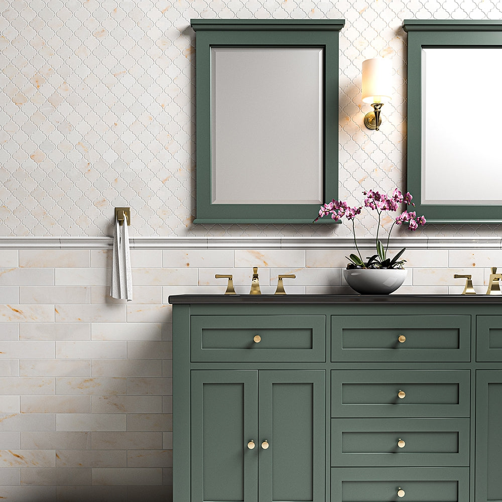 Bathroom with Calacatta Amber Marble tiles, green dual-sink vanity, gold fixtures, pink flower bowl, two mirrors, and a light fixture above.
