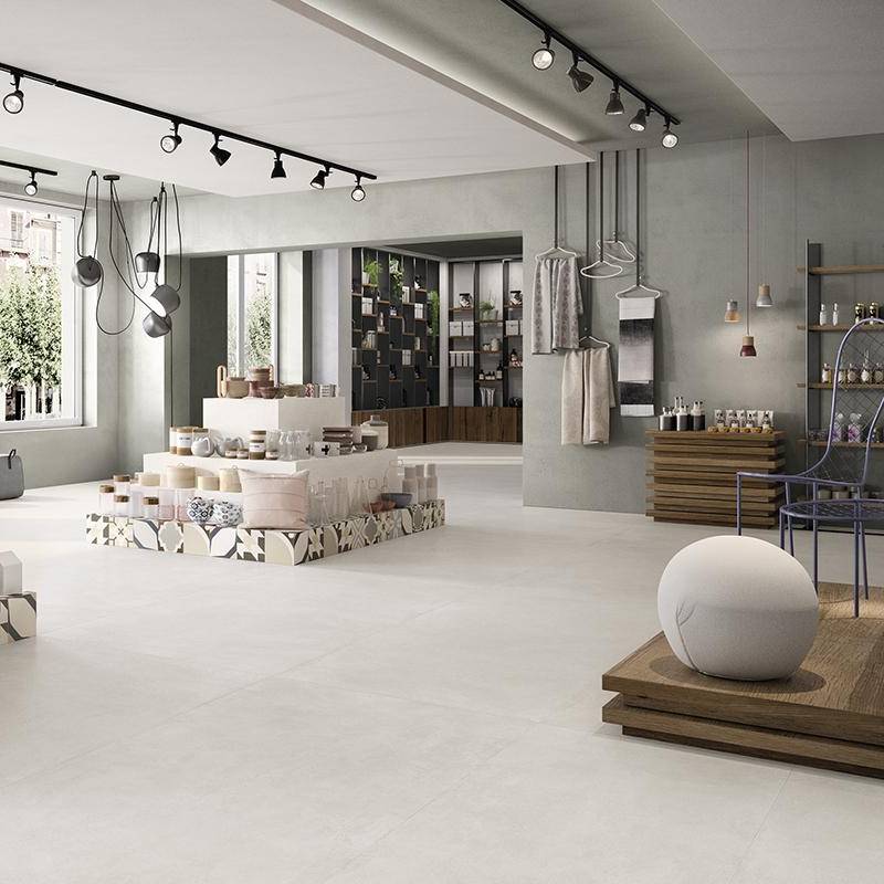 Modern minimalist showroom featuring concrete-look porcelain tiles with seamless design and neutral color palette