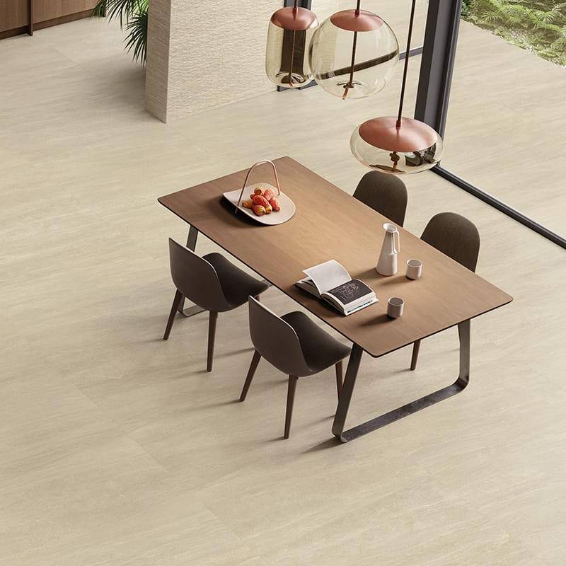 Modern dining room featuring sandstone stone-look porcelain tile flooring from Surface Group collection with stylish table and chairs set