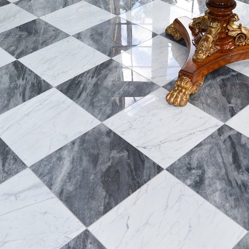 Black & white checkered marble flooring with ornate gold detailing on wooden table leg.