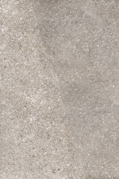 Matte porcelain tile with rugged dolomite texture in soft gray, evoking Appalachian stone strength and organic modern elegance.