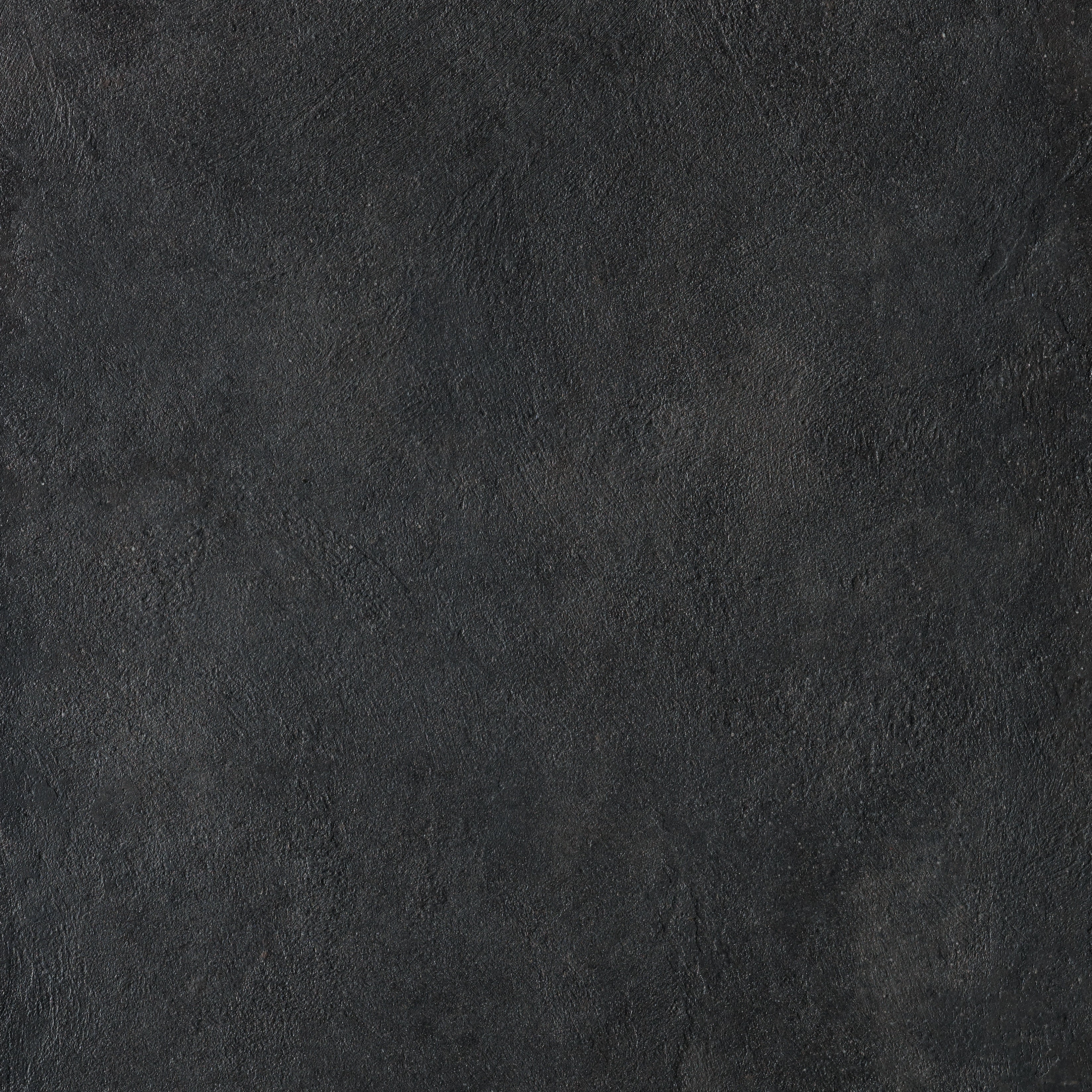 Matte black porcelain tile with urban concrete texture, exuding brutalist elegance and minimalist sophistication for refined interiors.