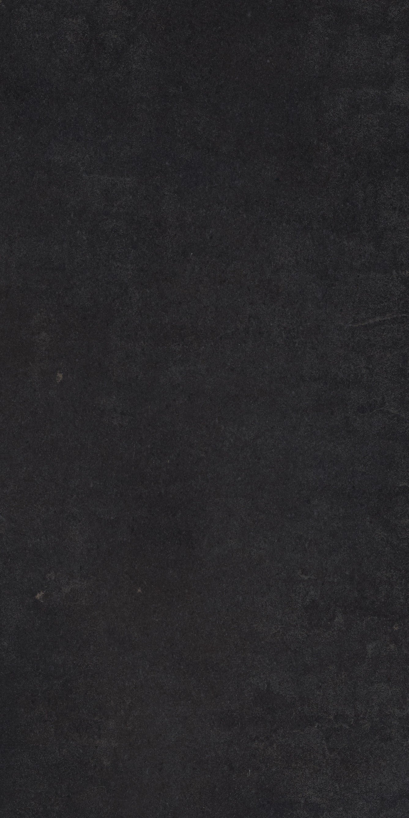 Matte black full-body porcelain tile with a sleek, minimalist aesthetic and refined pressed edges for modern interiors.
