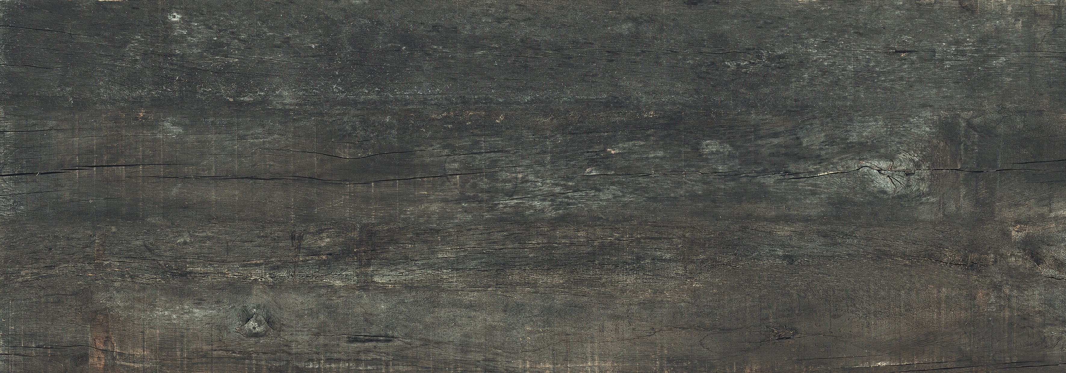 Sun-dried wood-look porcelain plank with deep matte texture and warm black-brown hues, evoking rustic elegance and organic modern charm.