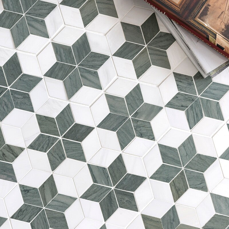 Geometric mosaic tile pattern with stars and diamonds in green and white shades. Multi-finish surface with stack of books in top right corner.