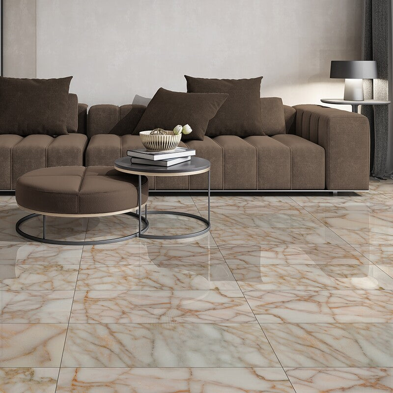 Modern living room with dark brown tufted sectional, round ottoman, metal coffee table, marble floor, and contemporary lamp with round shade.