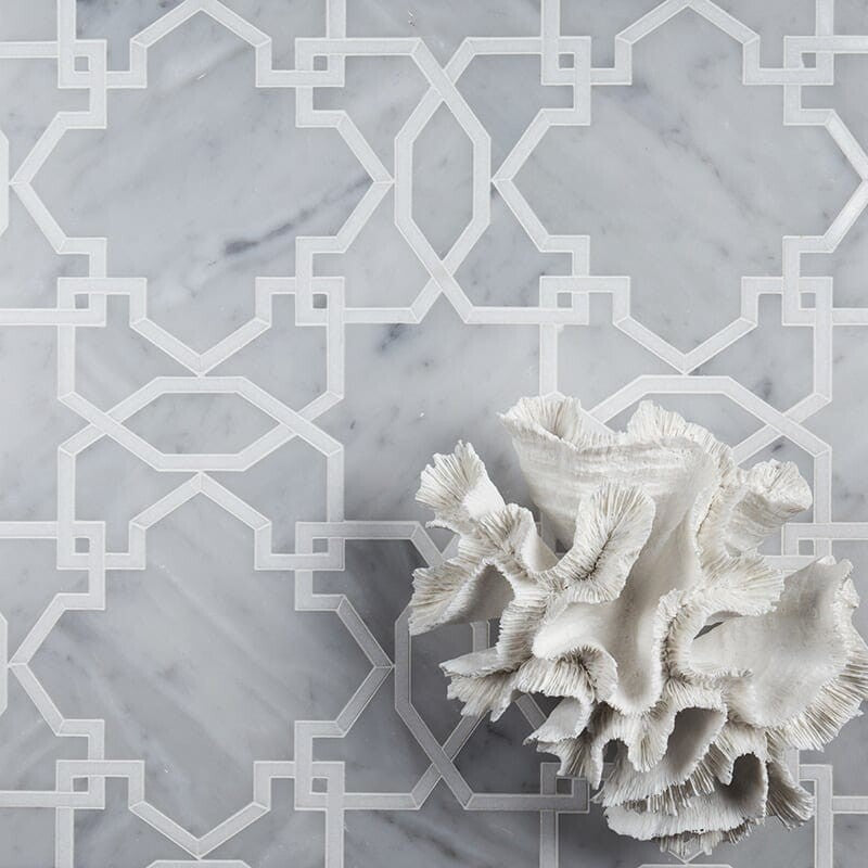 Geometric white and gray marble tile with intricate shapes, white coral accent in lower right corner.