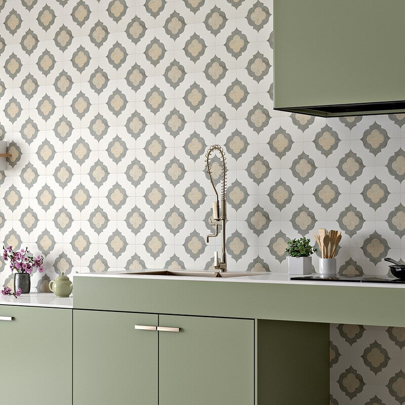 Kitchen interior with intricate mosaic backsplash in champagne, olive green, and seashell colors. Green cabinetry, white countertop, modern fixtures.