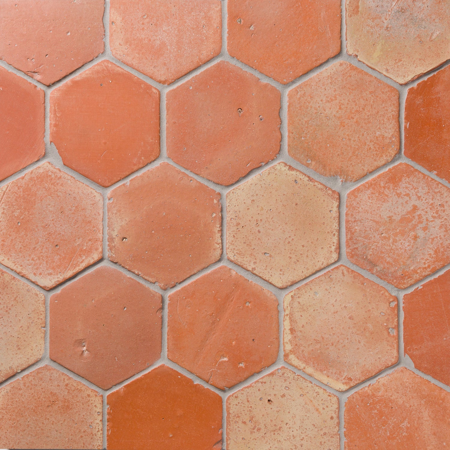 A display of rustic hand-pressed terracotta tiles from the Cotto Andaluz collection, showcasing earthy tones and traditional Spanish craftsmanship.