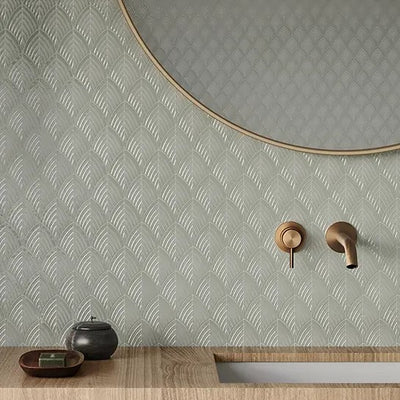 Minimalist bathroom design featuring Anatolia Soho Glazed Ceramic tiles with a subtle, geometric pattern in a calming gray hue, complemented by a contemporary round mirror and elegant bronze fixtures.